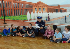 Wspólne zdjęcie policjantki z dziećmi na tle Manufaktury.